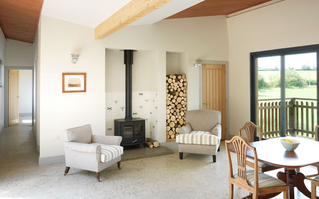 The living area of the Grand Designs house on stilts with a view of the wood burning stove in the centre of the space