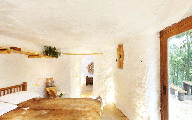 Whitewashed cave walls and a double bed keep things simple in the main bedroom of the Grand Designs cave house