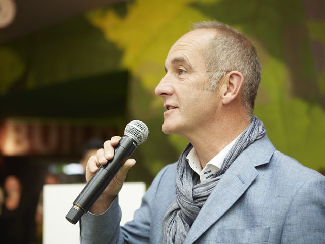 kevin mccloud speaking into a microphone at grand designs live