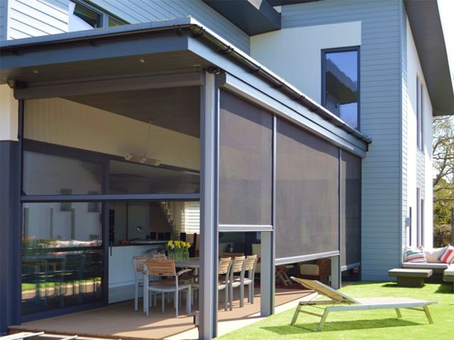 phantom screens' brise soleil installed in a house with a sunny garden to save energy 