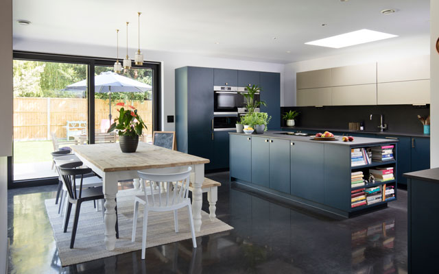Modern kitchen with dark grey cabinets and a pine-topped dining table