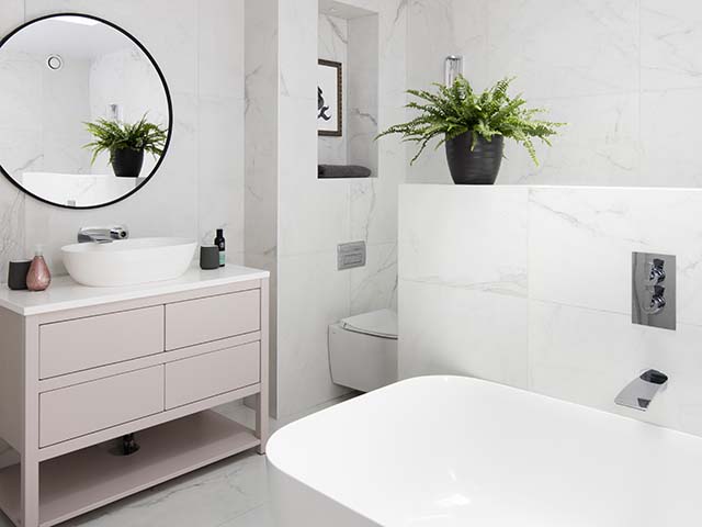 Bathroom with freestanding bath and pink vanity unit