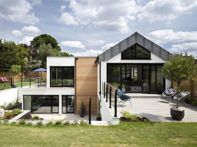 Exterior of Grand Designs healthy home with timber cladding and white render with sunken patio garden