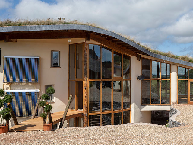 Outside of Grand Designs Cob House with floor to ceiling windows