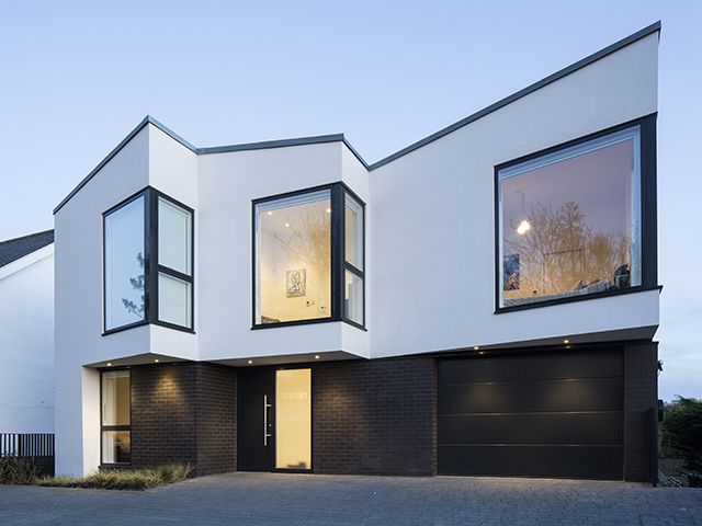white modern house with black frame windows by snug architects