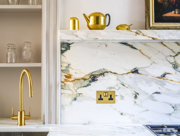 detail of kitchen with mixer taps and marble look splashback