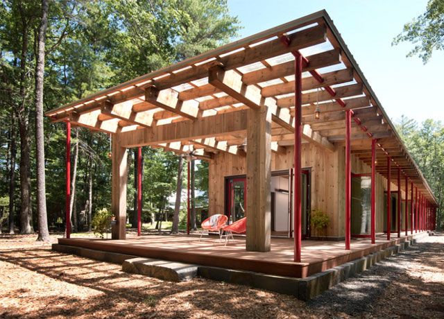 Wooden garden room with red panels and integrated doors by North River Architecture