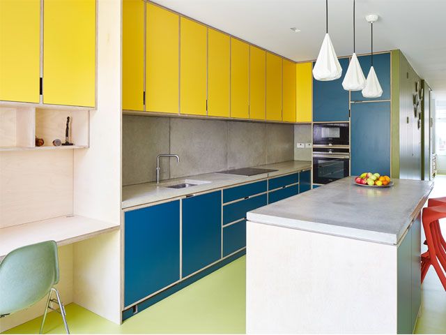 A home office, work space creates as an extension of a kitchen with yellow and blue cabinets -r2-architects-home-improvements-granddesignsmagazine.com