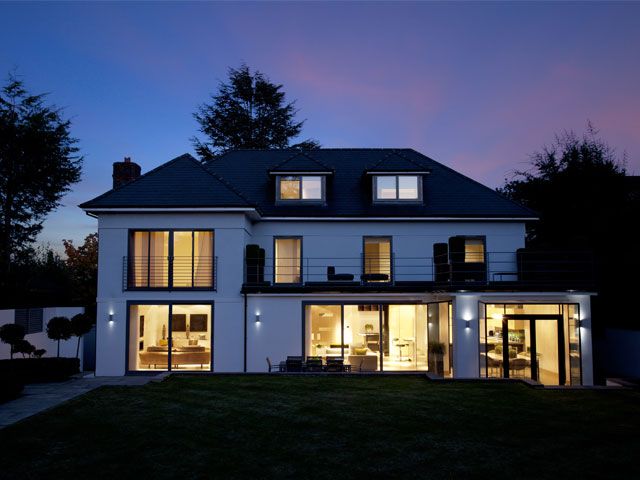 A white house with a grey roof and a large back garden -lutron-home-improvements-granddesignsmagazine.com