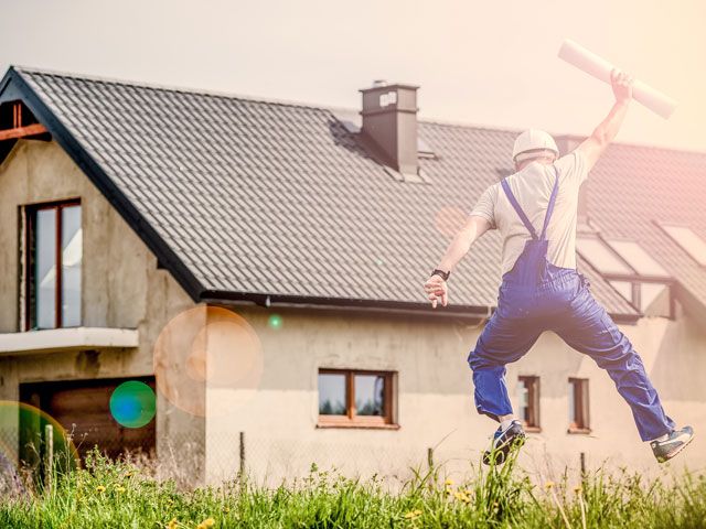 Man Jumping in Front of House 