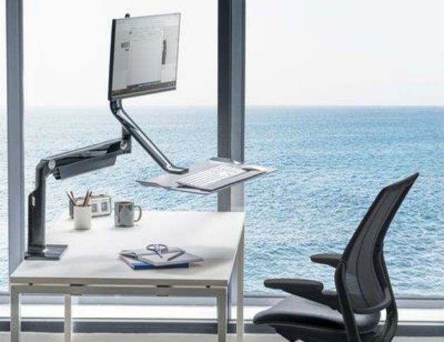 A smart chair and workstation next to a window overlooking the sea