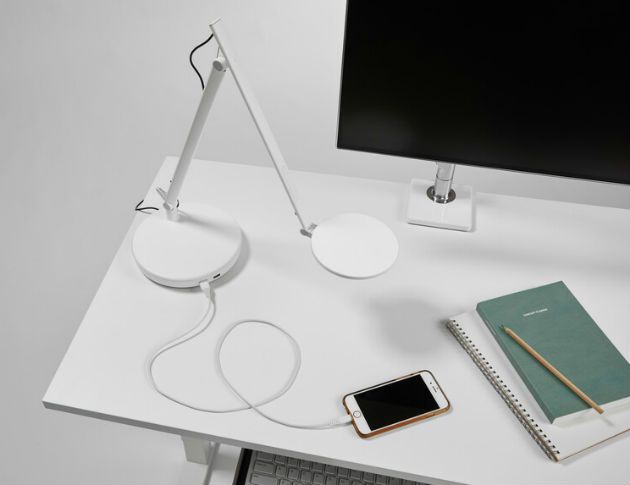 Desk with phone monitor notebook and adjustable lamp