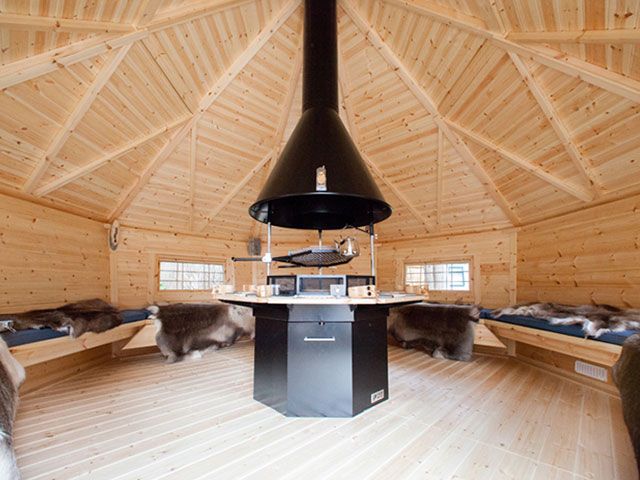 interior of wooden garden cabin with bbq seating and rugs