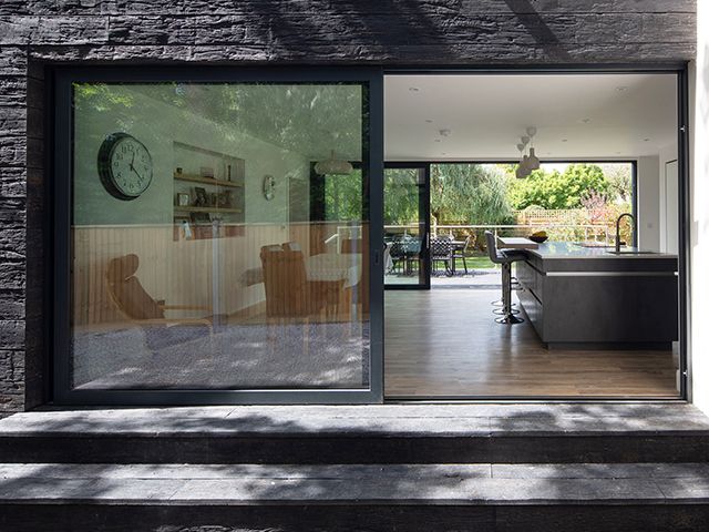 footprint architects charred timber house - sliding doors to kitchen - alex campbell photography - granddesigns 