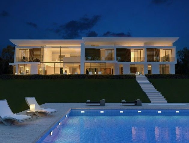 modern white home with swimming pool at night