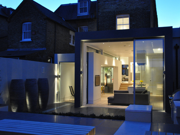 rear of home with doors opening out onto a patio copy