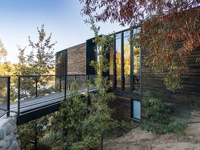 timber clad modern house set onto hill slope - grand designs 