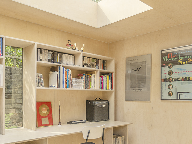 Garden office clad in textured cork sheets and fitted with bespoke wooden shelving by Surman Weston 