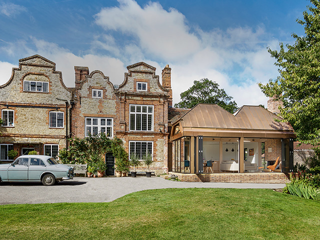 extension to old mill house with pitched bronze roof - grand designs