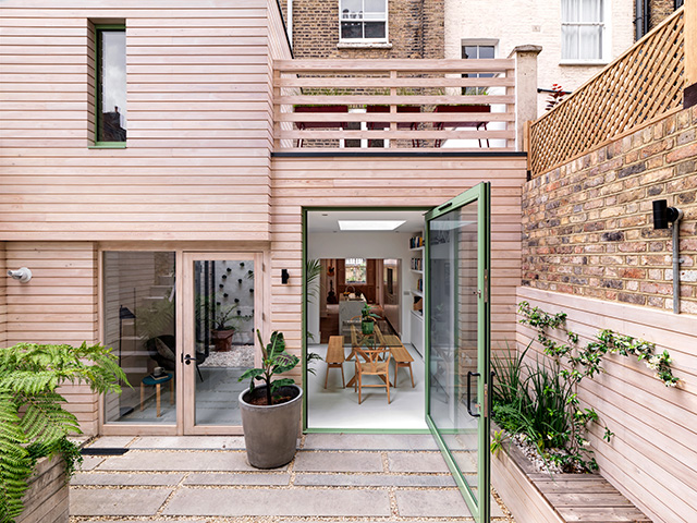 timber clad extension with green glazed door - grand designs