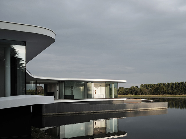 modern curved white house on lake side - self build homes - grand designs