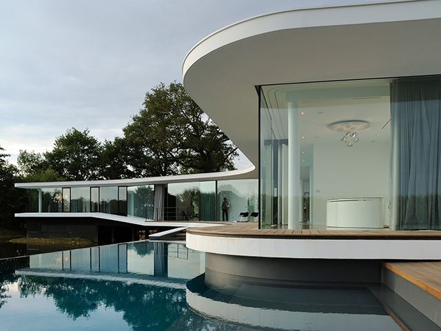 modern curved white house on lake side - self build homes - grand designs