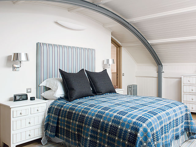 Double bed with blue tartan duvet and white furniture
