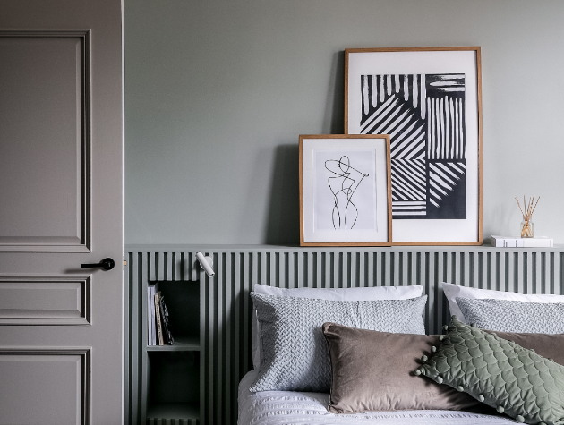 bedroom in muted colours with cushions and artwork