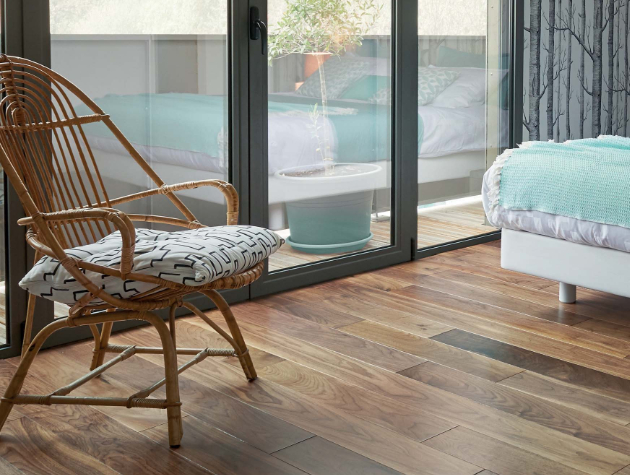 bedroom with bed chair wooden flooring and doors to patio