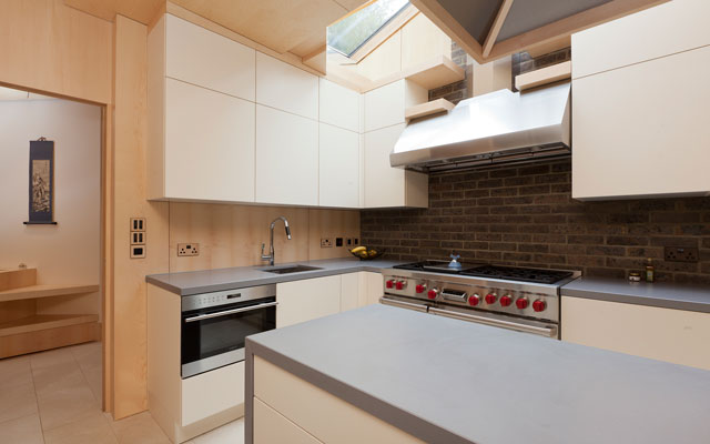 A compact kitchen with handless doors in a pale cream colour