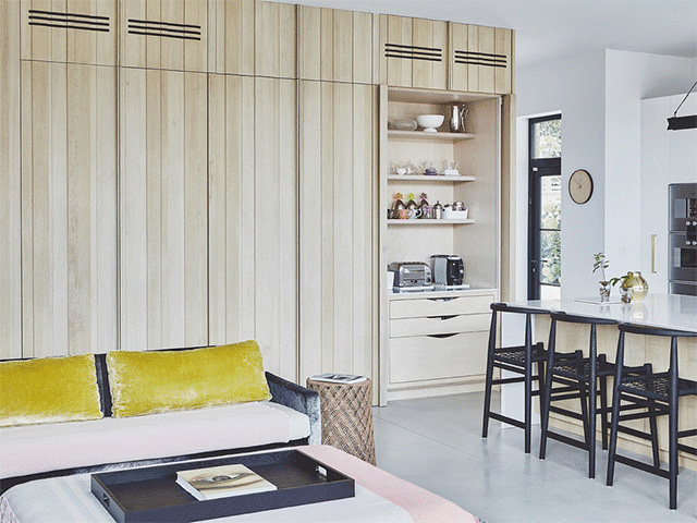 Open-plan kitchen, dining and living room with a wall of handleless kitchen cabinets 