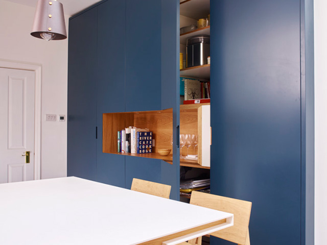 handleless kitchen with floor to ceiling blue doors with cut-out shelf 