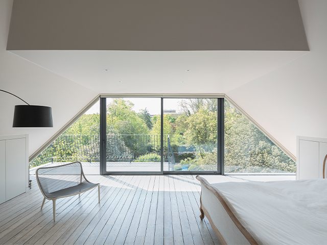 A loft conversion bedroom with big glazed doors leading onto a balcony