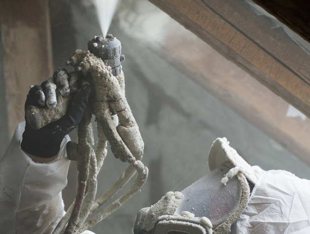 person in protective suit using foam gun