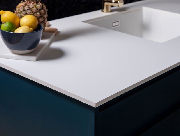 white worktop with inset sink and bowl of fruit