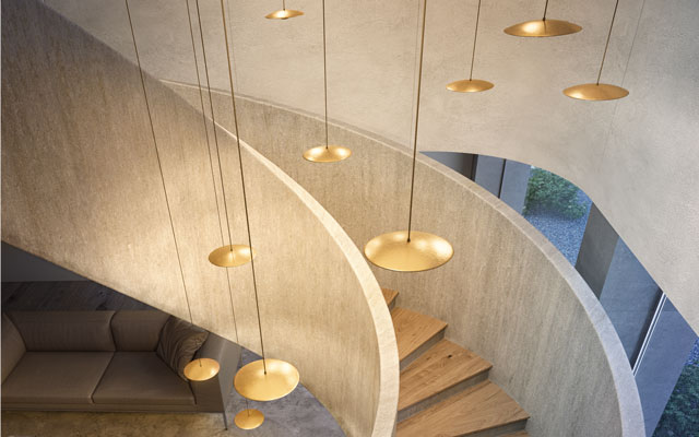 Several pendant lights grouped together and hanging above a stairwell