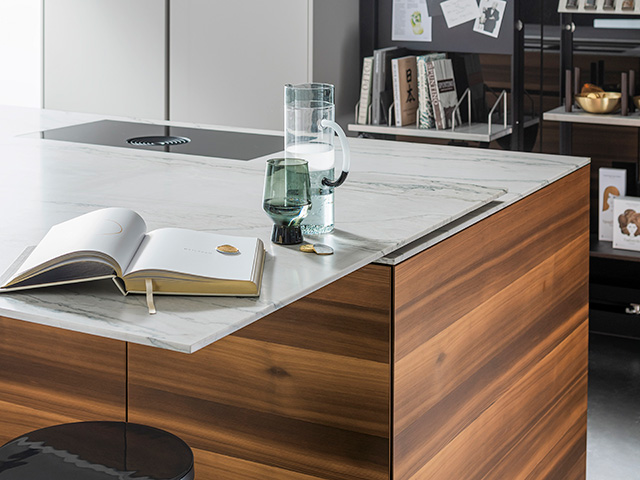 Close-up of the Motion worksurface from Eggersmann that moves outward from an island unit to create a tabletop