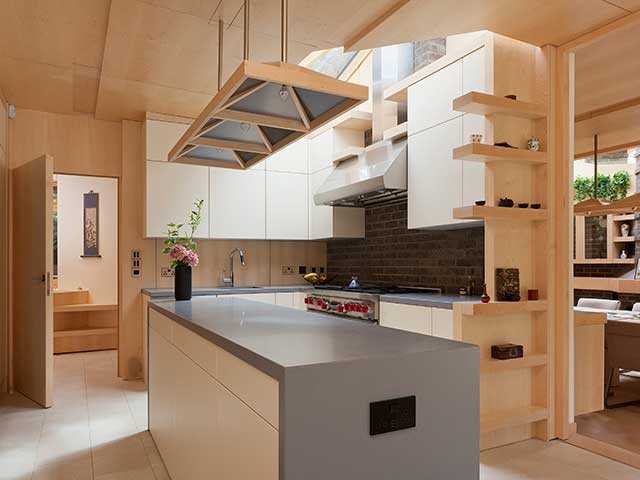 Kitchen with minimalist scheme and grey kitchen island in the centre with a ceiling light hanging above