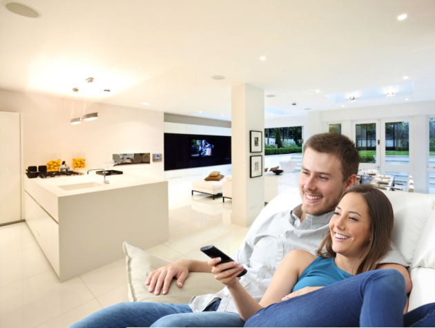 man and woman watching television in open plan home