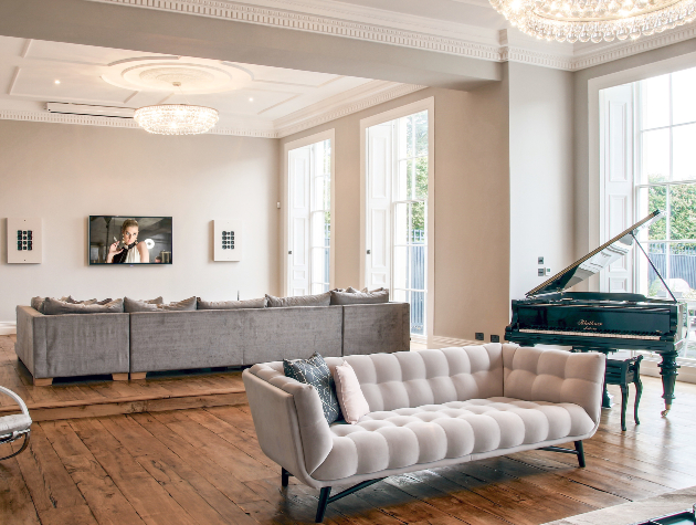 open plan room with sofas piano and wall mounted television