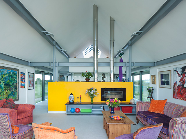 Bright coloured living area with exposed steel beams and stove pipes