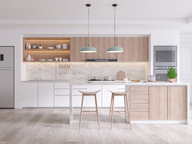 modern fitted kitchen in light wood with stools and pendant lights