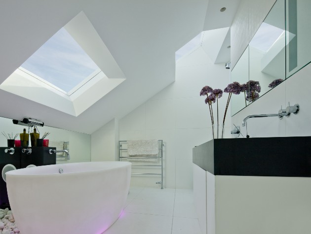 modern white bathroom with freestanding bath and rooflight