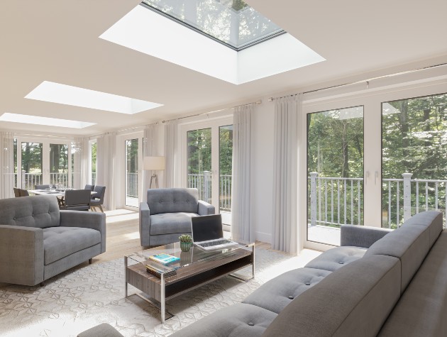 open plan sitting and dining room with grey sofa patio doors and rooflights