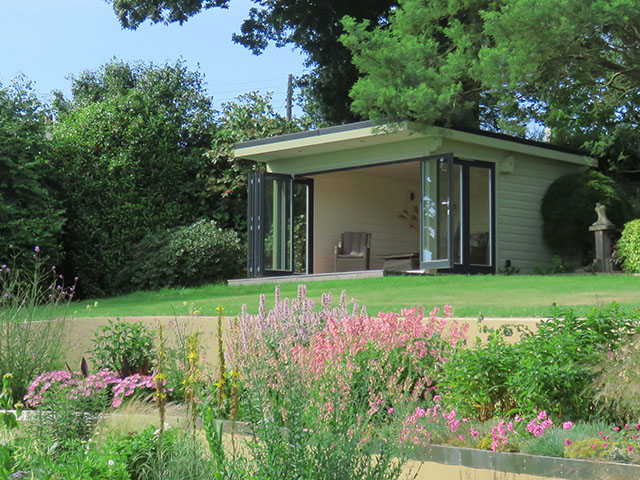 Large garden room with bi-folding doors overlooking a terraced garden