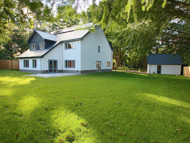 white new build house in garden with trees 