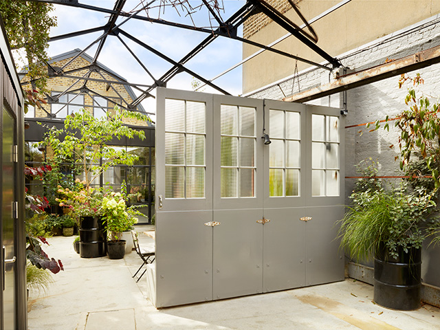 Steel girders and an industrial pergola stand over the courtyard garden