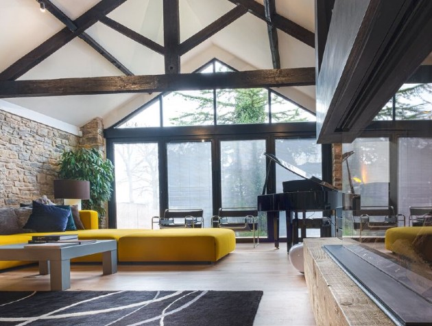 interior of converted barn with piano and yellow sofa