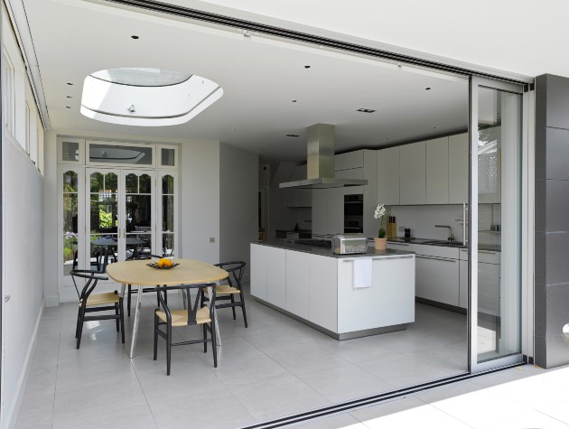 kitchen and dining area in white seen through an open sliding door