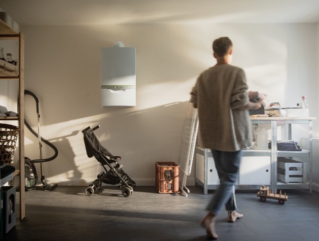 person walking through home store room with pram vacuum and boiler